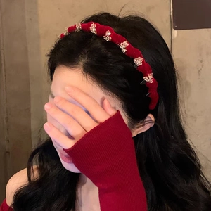 Detail shot of a red crystal velvet headband with bear ornaments on a model