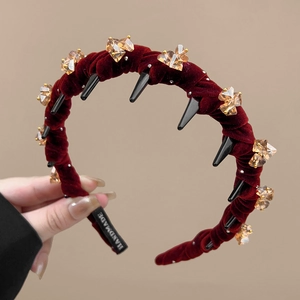 Close-up of wine red velvet headband with champagne crystals and non-slip inner teeth