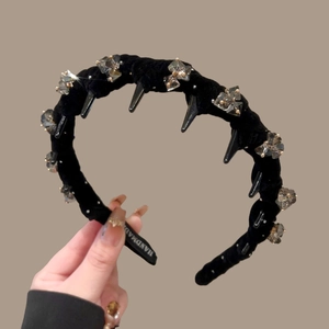 Detail showing black velvet headband with clear crystals and spikes, handmade text inside