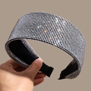 Close-up detail of luxurious wide headband featuring densely inlaid sparkling rhinestones
