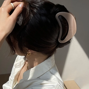 Pince à cheveux minimaliste ajourée en demi-lune couleur beige crème portée