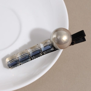 Vue détaillée de la pince à cheveux avec perle champagne et cristaux bleus carrés