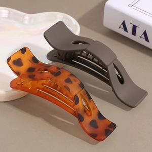 Matte bow-shaped hair claw clips set in dark taupe and leopard print pattern