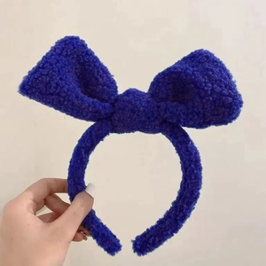 Detailed texture of royal blue plush lamb wool fabric on a wide bow headband
