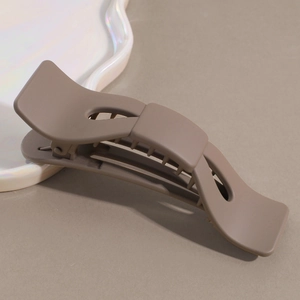 Detail shot of mocha brown matte hair claw clip with non-slip teeth on aesthetic tray