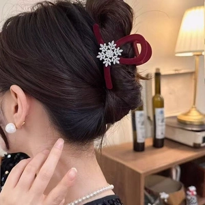 Elegante pinza per capelli in velluto bordeaux con fiocco di neve in strass su modella