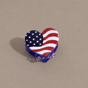 Detail of heart-shaped USA flag hair claw clip with blue glitter and star pattern
