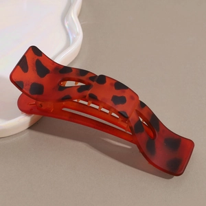 Close-up of matte orange leopard print hair claw clip with tortoise shell pattern details