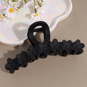 Matte black frangipani flower hair claw clip with minimalist floral design for women