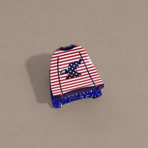 Detail view of mini USA sweater hair claw clip with blue glitter base and eagle design
