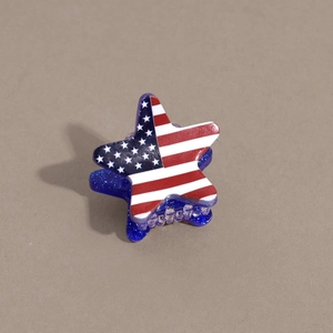 Macro detail of the star-shaped hair claw clip with American flag pattern and blue glitter