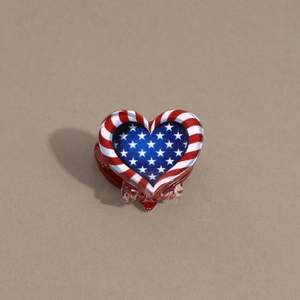 Macro detail of the heart-shaped hair claw clip with American flag stars and stripes pattern