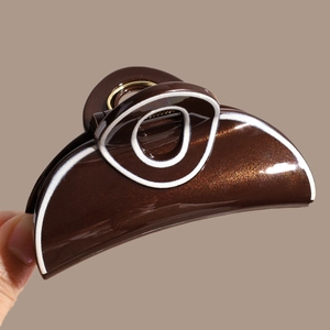 Macro shot of brown hair claw clip with fine glitter and elegant white line detailing