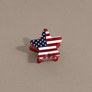 Detail of star-shaped hair claw clip with American flag pattern and red glitter finish
