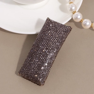 Detail of elegant rectangular hair clip with shimmering dark purple rhinestones