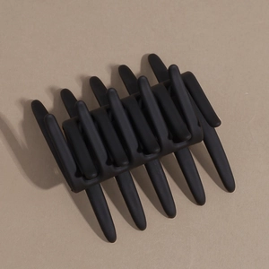 Macro detail of the black matte hair comb with cross teeth for securing hairstyles
