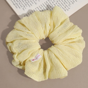 Détail d'un chouchou froncé couleur crème avec étiquette handmade et petit cœur rouge