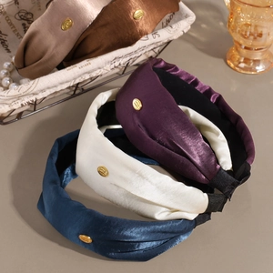 Elegant wide satin headbands with gold logo in navy, beige, purple, and brown tones