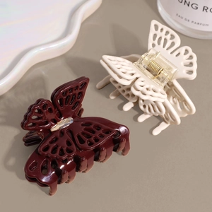 Elegante Schmetterlings-Haarklammern in Burgund und Creme mit Strass auf Sandhintergrund