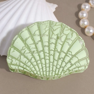 Detailed view of sea shell hair claw clip with cracked texture and pearl accessories