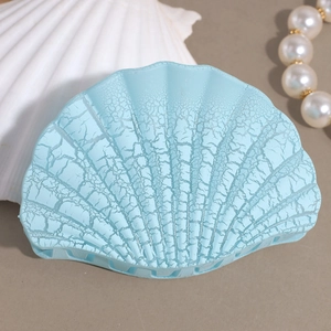 Detailed shot of a blue shell-shaped hair claw with crackle texture and resin finish