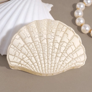 Macro detail of cream floral shell hair claw with artistic ice crackle texture finish