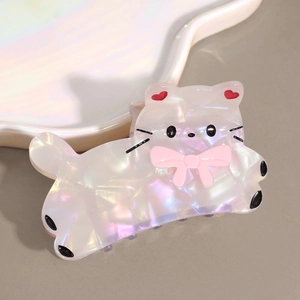 Détail macro de la pince à cheveux chat blanc irisé avec un nœud rose et oreilles en cœur