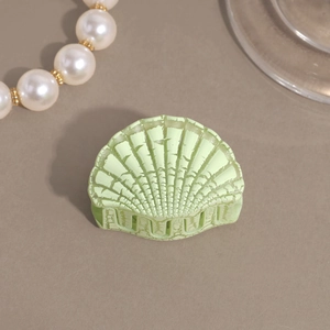 Close-up of mint green shell hair claw clip with vintage crackle texture for women