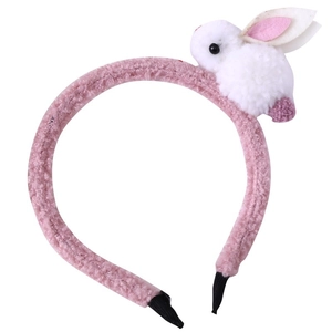 Détail d'un serre-tête en peluche rose avec un ornement de lapin blanc pour filles