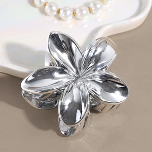 Dettaglio della molletta per capelli a forma di fiore in metallo argento lucido