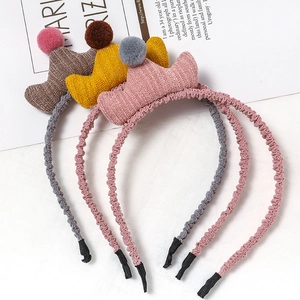 Détail de trois serre-têtes couronne en tricot pour princesse avec pompons multicolores