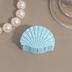 Macro detail of a light blue shell hair claw with crackle texture and anti-slip teeth