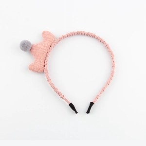 Détail d'un serre-tête en tissu rose avec couronne tricotée et petit pompon gris