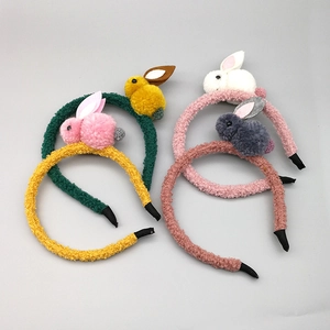 Détail de quatre serre-têtes en peluche lapin colorés avec tissu doux et petits lapins pompons