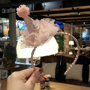Detail of pink princess headband with sequined party hat, lace trim, and plush pom-pom