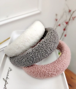 Texture dei cerchietti in peluche spessi in bianco, grigio e rosa su un vassoio