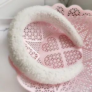 Dettaglio del cerchietto in peluche bianco con morbida trama in pile e design imbottito
