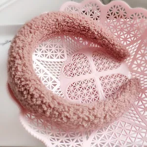 Dettaglio di fascia per capelli in peluche rosa con design largo e ispessito in lana