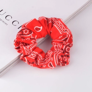 Detail of red paisley scrunchie made of soft cotton fabric on a white background