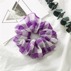 Detailaufnahme des violett-weiß karierten Chiffon-Haargummis mit Faltenstruktur