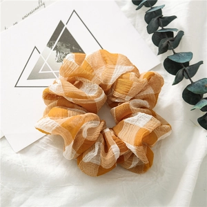 Detail eines orange-weiß karierten Haargummis mit weicher Chiffon-Stoffstruktur