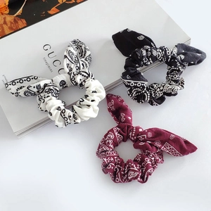 Three-piece set of paisley print bunny ear scrunchies in black, white, and red fabric