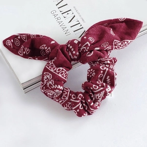 Burgundy paisley print scrunchie with rabbit ear bow on a clean white background