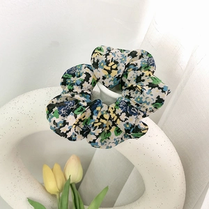 Detailtextur eines floralen Chiffon-Haargummis mit blauen und gelben Mustern