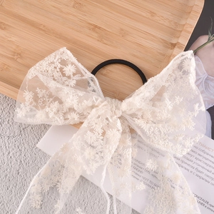 Detailed view of white floral embroidered lace bow hair scrunchie with elastic band