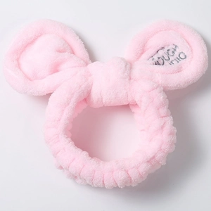 Detailed view of pink plush headband with soft coral fleece texture and Touch Me embroidery