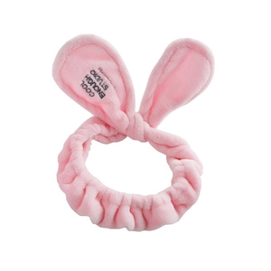 Detail of pink plush rabbit ear headband with soft coral fleece texture for facial cleansing
