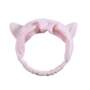 Detail of pink plush headband with cute cat ears and soft elastic band for skincare