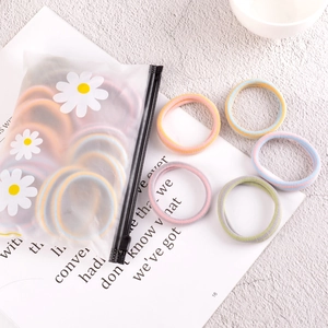Lot d'élastiques à cheveux multicolores sans couture dans une pochette marguerite