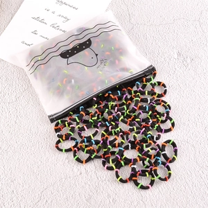 Gros plan d'élastiques à cheveux multicolores sans couture sortant d'un sac givré